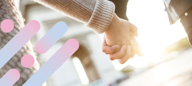 Woman and man hold hands in city