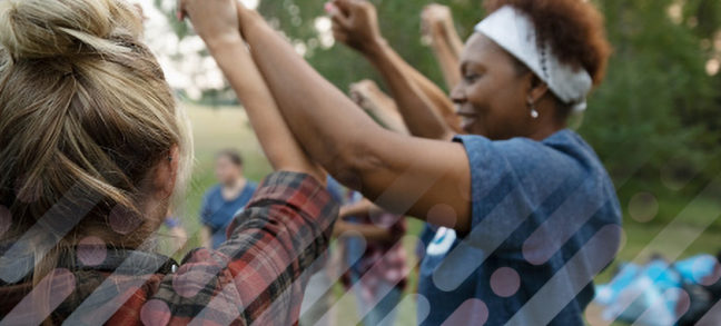 Women link hands, arms raised