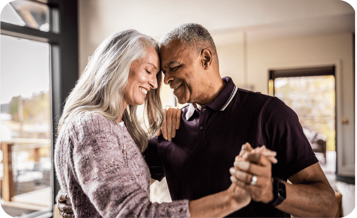 A man and woman dance together in a living room